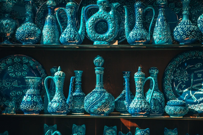 several ceramic jugs are displayed on a shelf