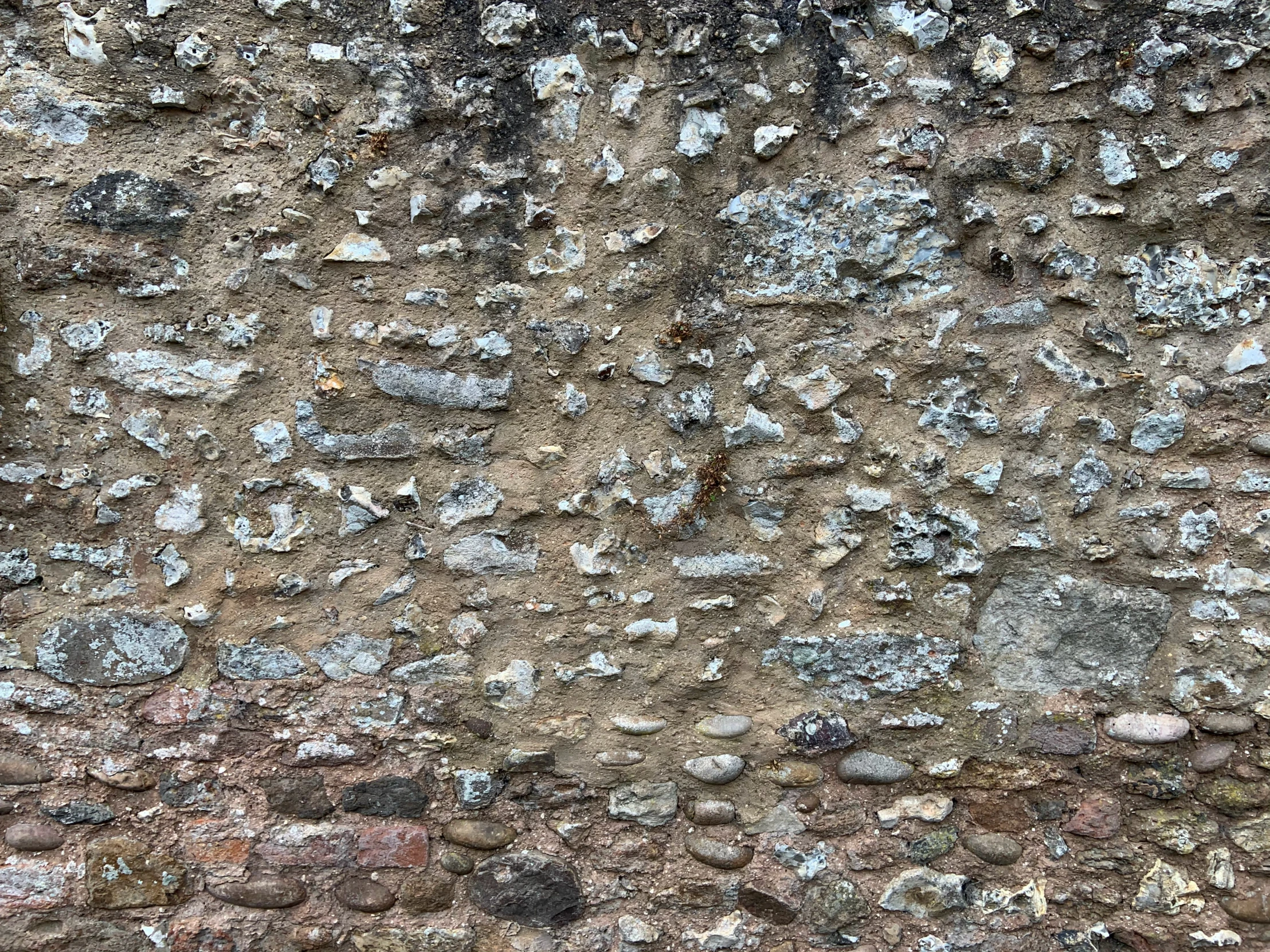 small, dark rocks cover the wall and ground