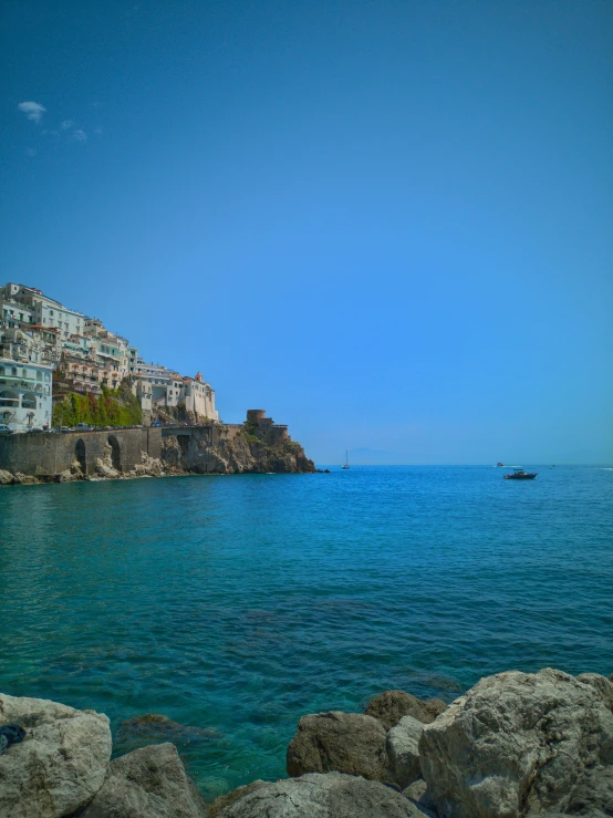 the shoreline has been rocky and there is a boat sailing