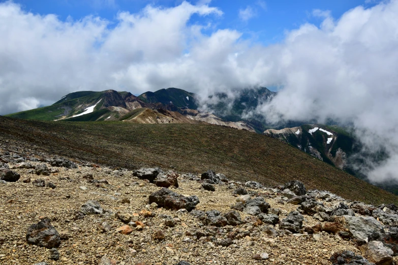 rocks and gravel on top of a mountain under clouds