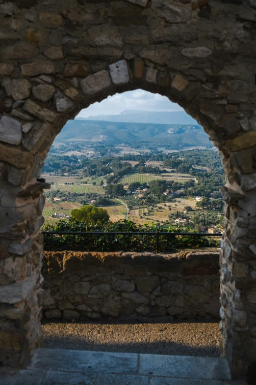 the view is from inside a stone tunnel