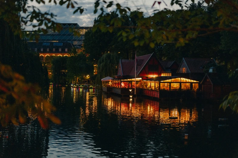 houses are lit up at night near the water