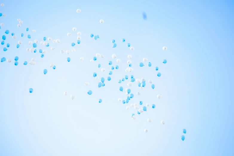 several blue and white balloon floats flying in the sky