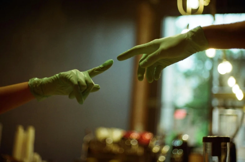 two people with green hand costume in front of a window