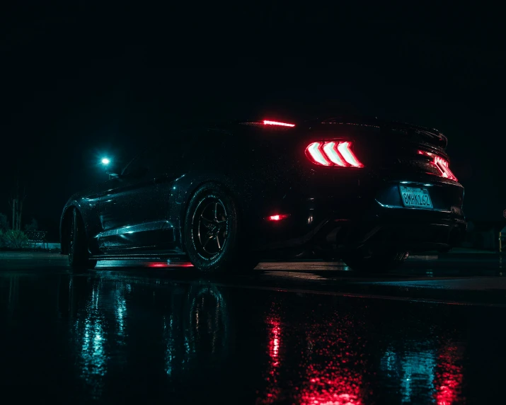 a car parked in the dark on a wet street