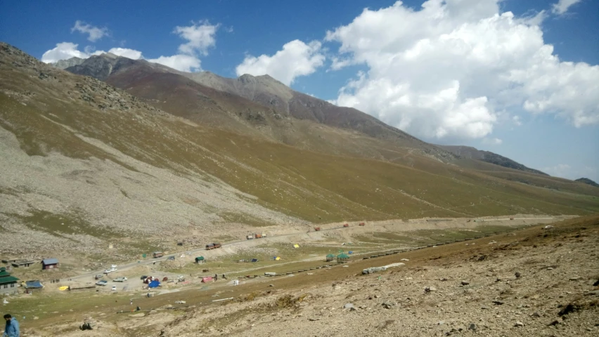 a very mountainous terrain with tents and people