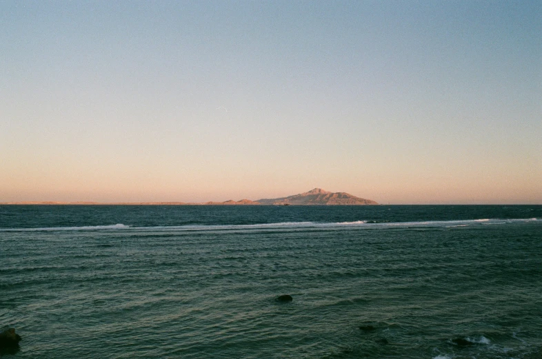 an ocean view with mountains and blue sky