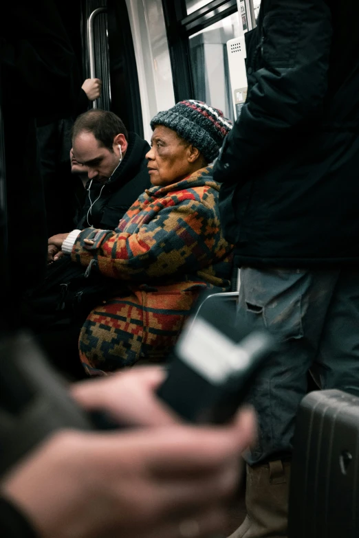 people seated on a train with their cell phones in hand