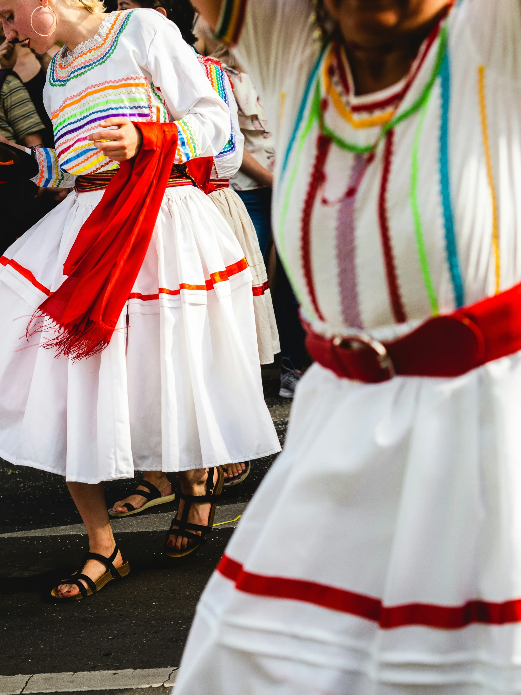 some women dressed in different outfits walking on a street