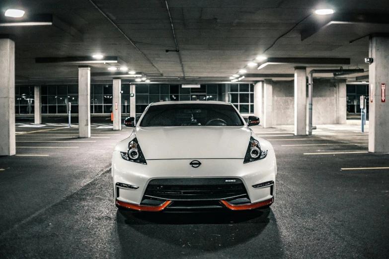 a white car parked in a parking garage with lights