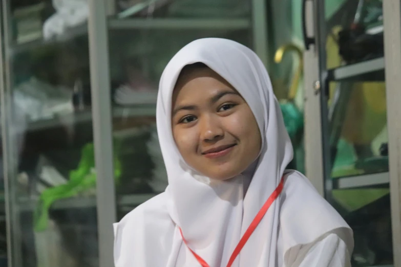 a girl is smiling with a white jacket and orange lines on her chest