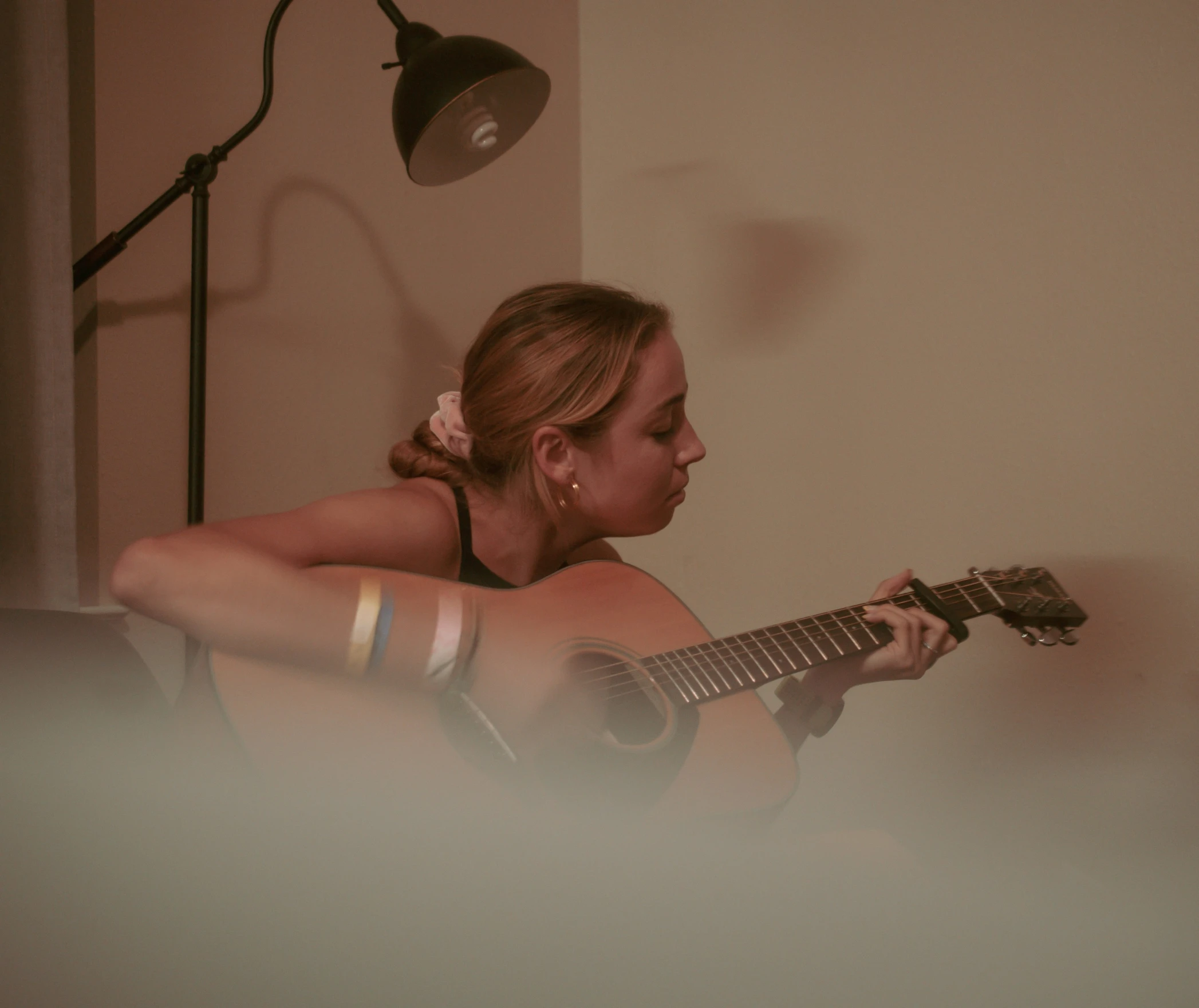 a woman in black shirt playing an electric guitar