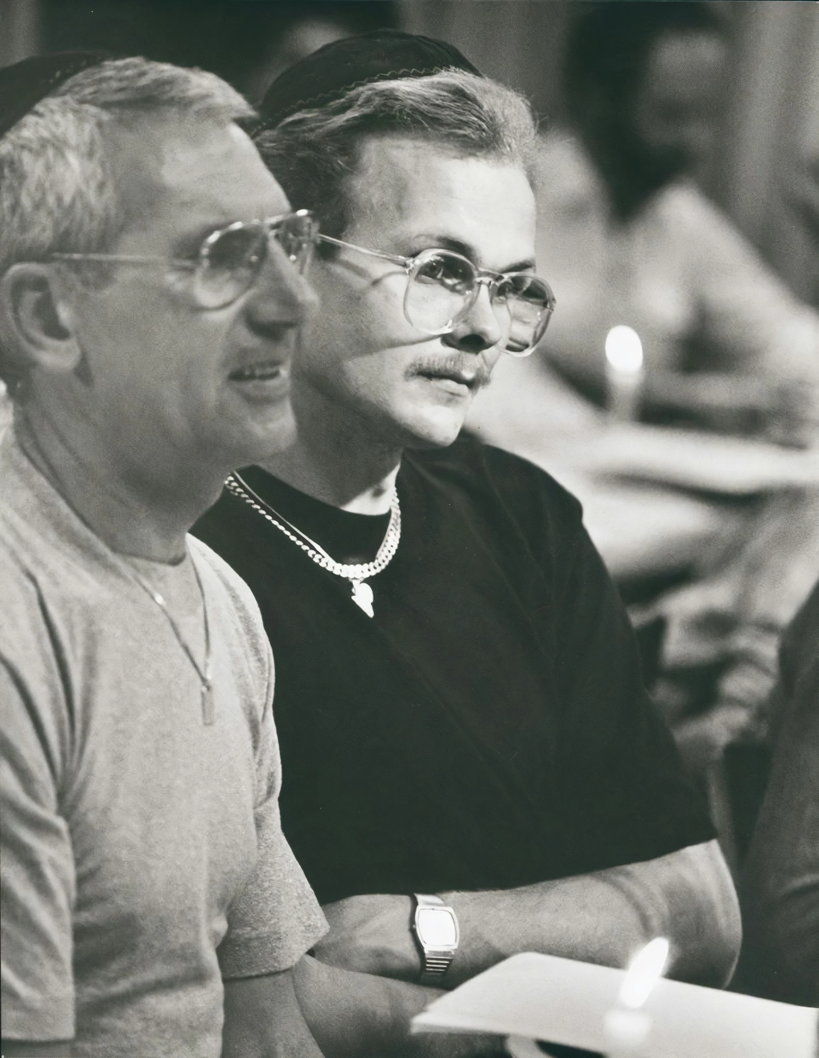 two men are at a table and one is holding a paper