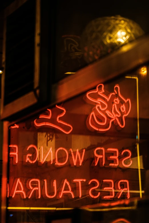 red neon sign hanging from the side of a building