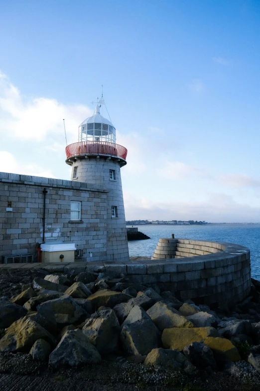 a view of a lighthouse in the ocean from a shore