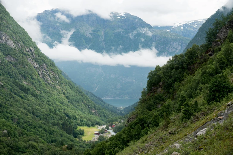 the sky is almost covered by clouds as the mountains sit near them