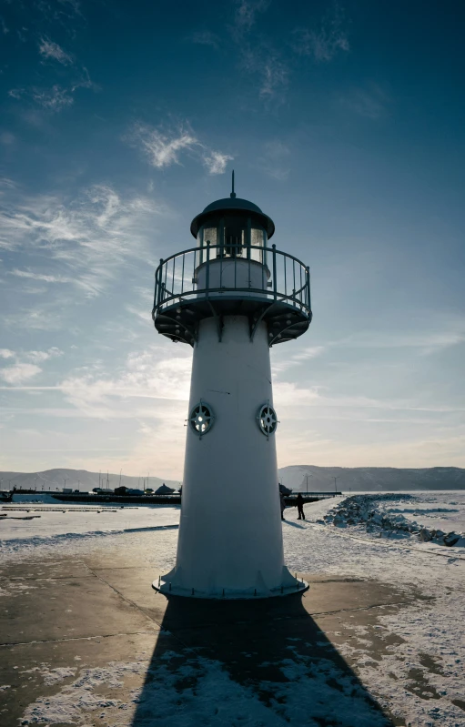 a lighthouse sitting on top of ice covered ground