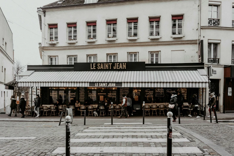 many tables, chairs and umbrellas in front of stores