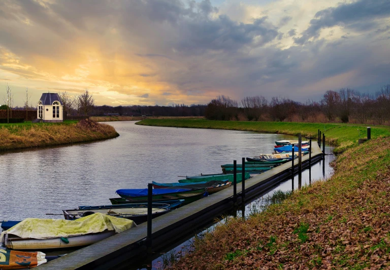 a boat dock on a river with boats lined up