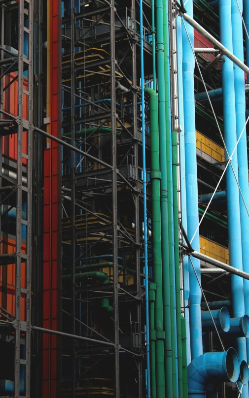 multiple pipes and a building covered in scaffolding