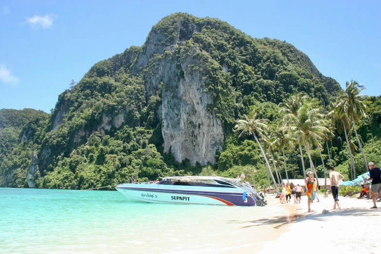 a white boat is parked next to the ocean