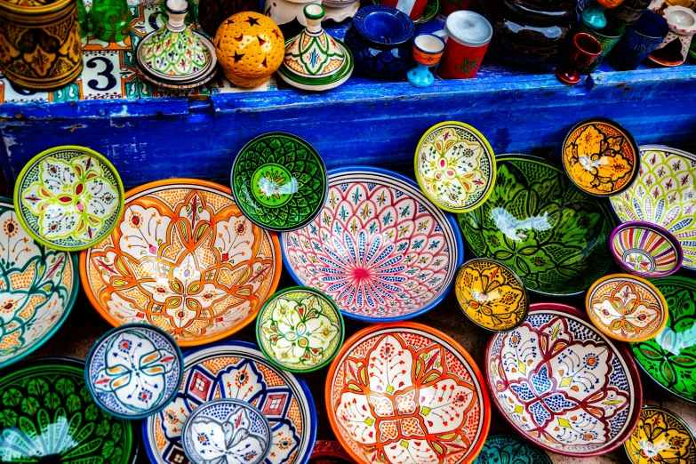 a collection of plates and bowls for sale in a market