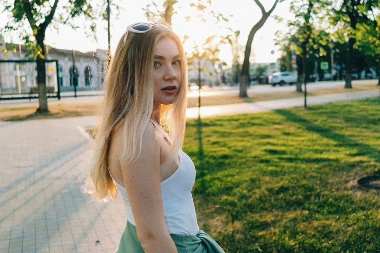 a woman standing on the grass in the street