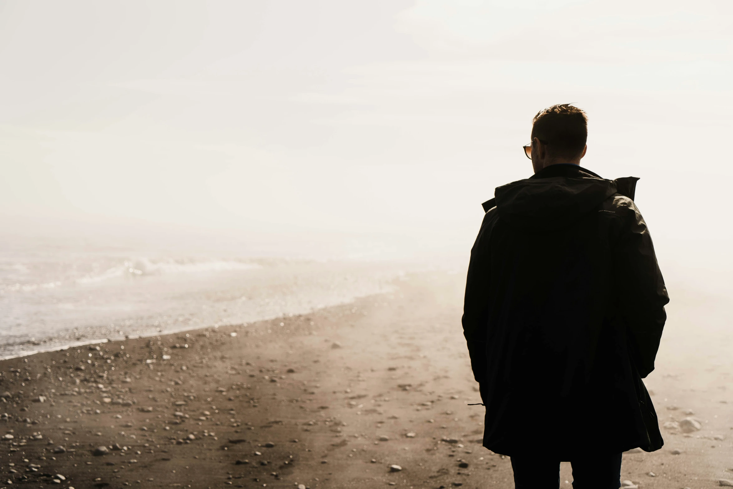 man standing by the water at the beach