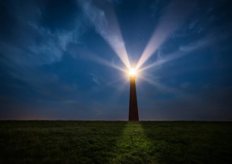 a lighthouse at night, on a grassy area