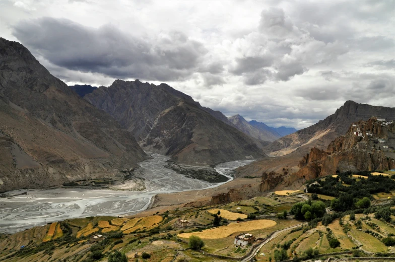 a river running between a few hills and the sky