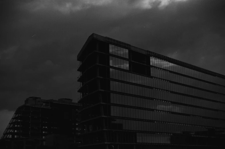 black and white pograph of building with clouds behind it