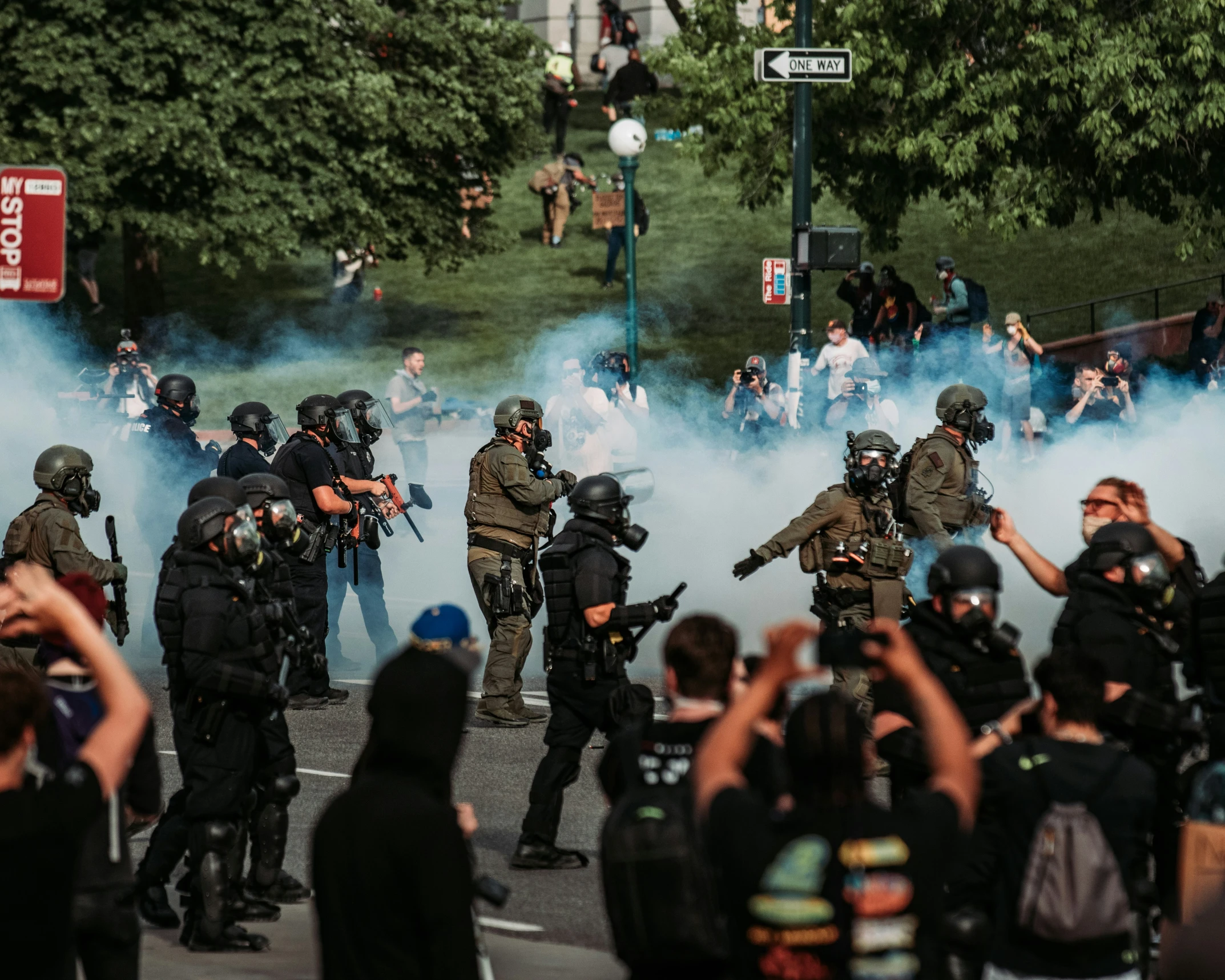 smoke emits as police move through the crowd