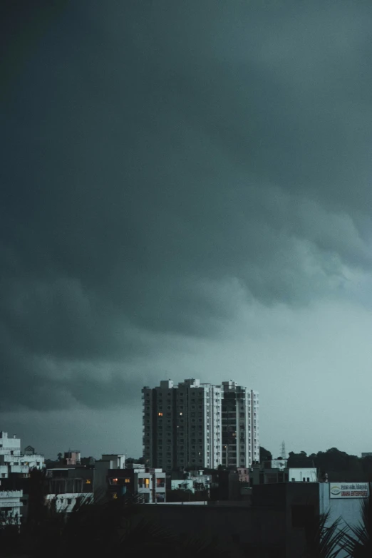 black and white pograph of buildings in front of a stormy sky