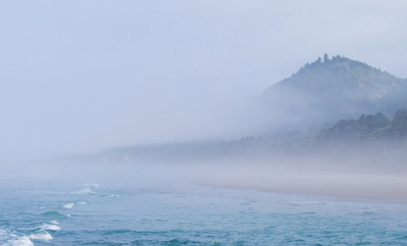 a foggy beach with low lying clouds