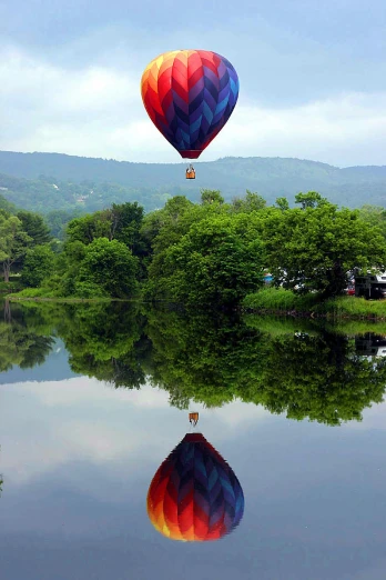 a lake with reflections in the water and  air balloons