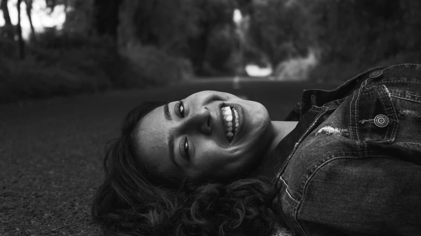 a woman is lying down on the grass