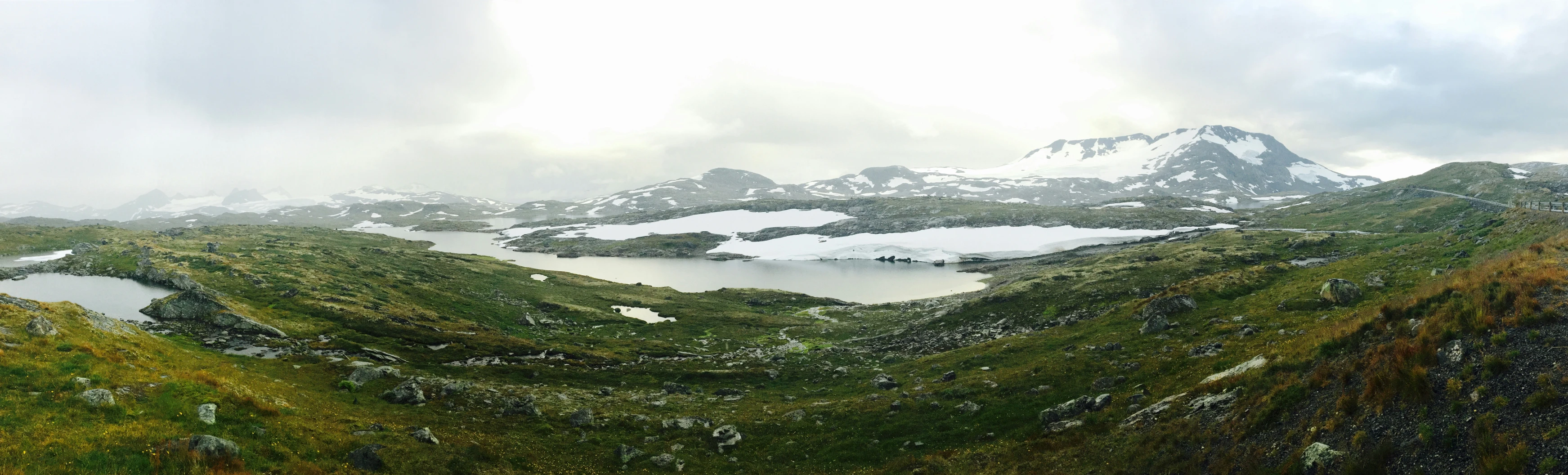 view from high up on a snow covered mountain range and lake