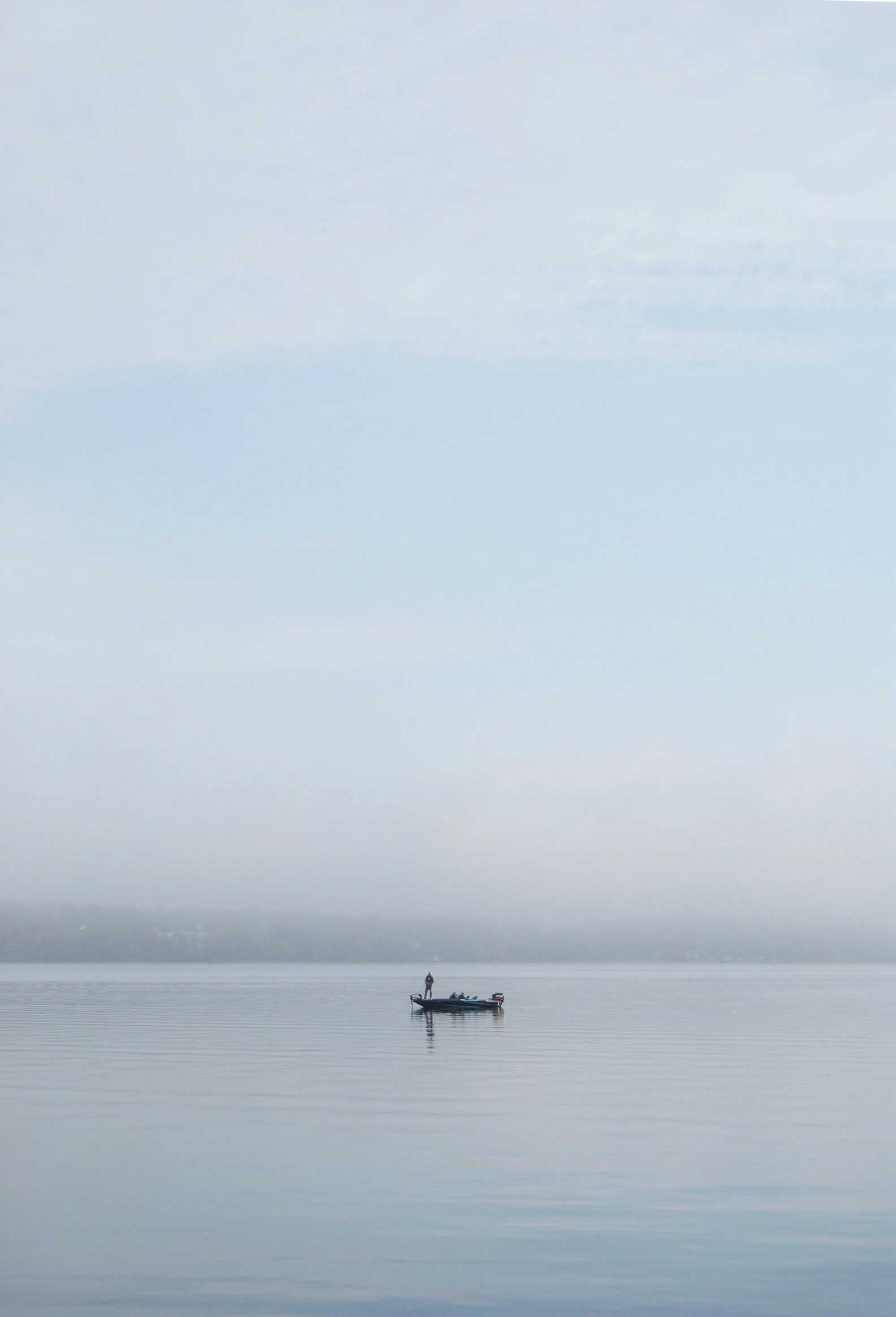 a person in a small boat floating in a large body of water