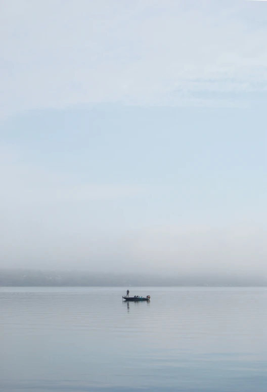 a person in a small boat floating in a large body of water