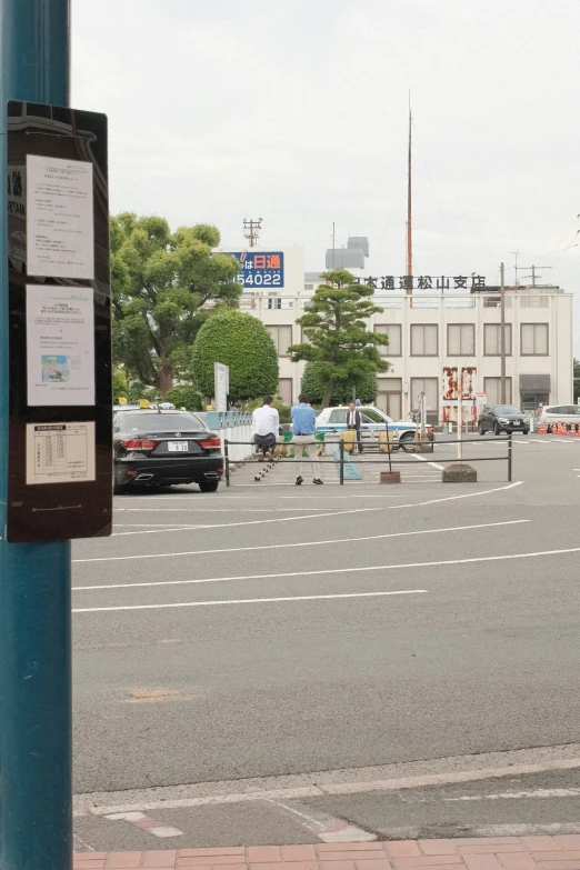 parking lot with parking meter, cars and sign on pole