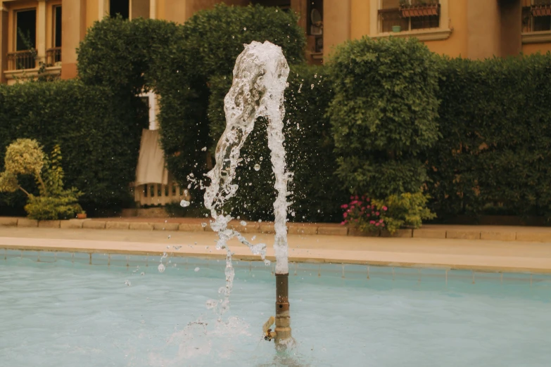 water is flowing from a fountain on a tiled swimming pool