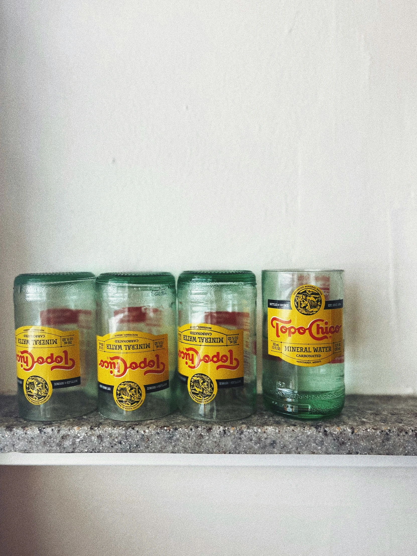 a row of old fashioned glass jars sit atop a marble ledge