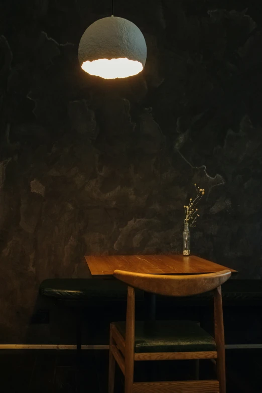 a wooden table sitting in front of a black wall