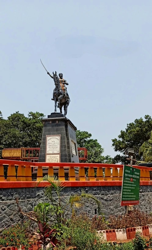 the statue is on top of an orange fence