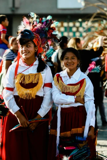 two s in traditional mexican costume smiling for a po