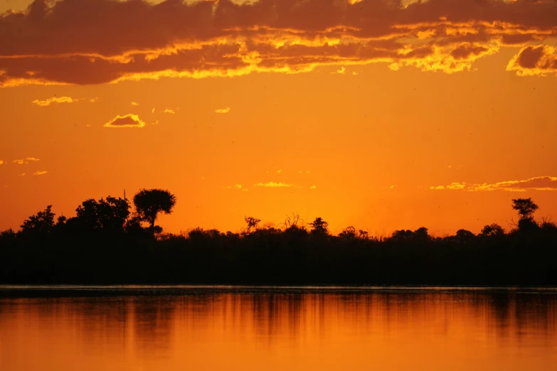 a bright yellow sunset with a small airplane in the distance