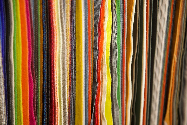 a bunch of different colored yarns hanging on the wall