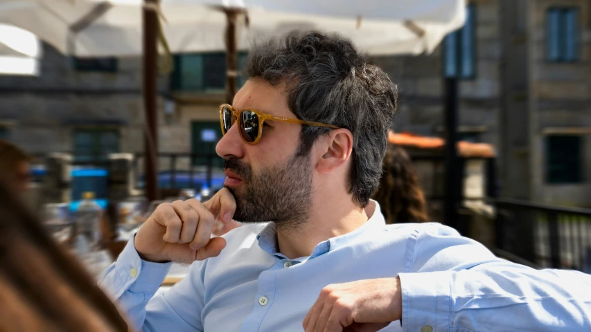 a man with sunglasses sits at a table