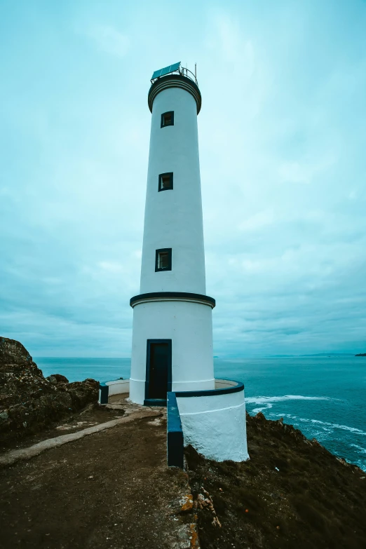 there is a white light house on top of the hill