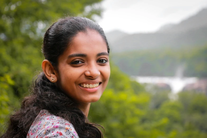 a woman with curly hair smiling at the camera